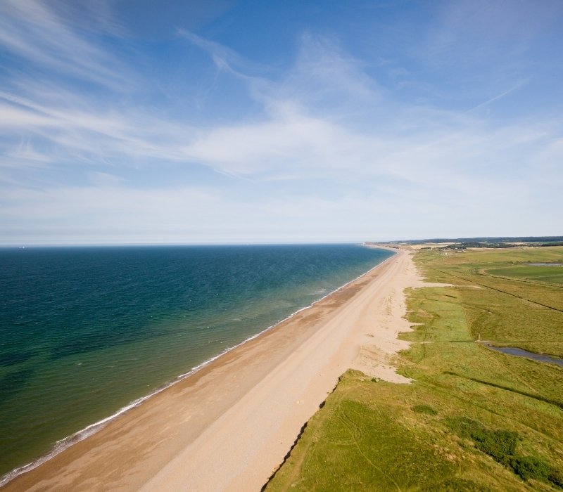 Norfolk coastline in summertime with sandy beaches and clear blue skies